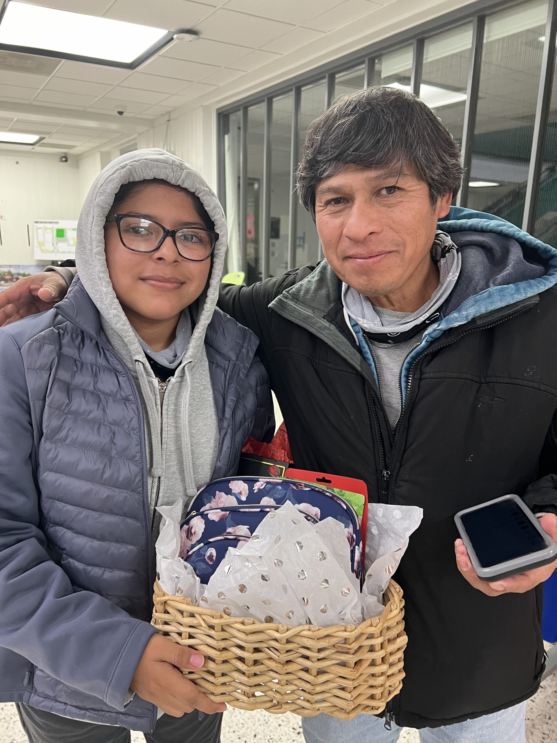 ACC student and community member hold one of the baskets gifted at the FACE event